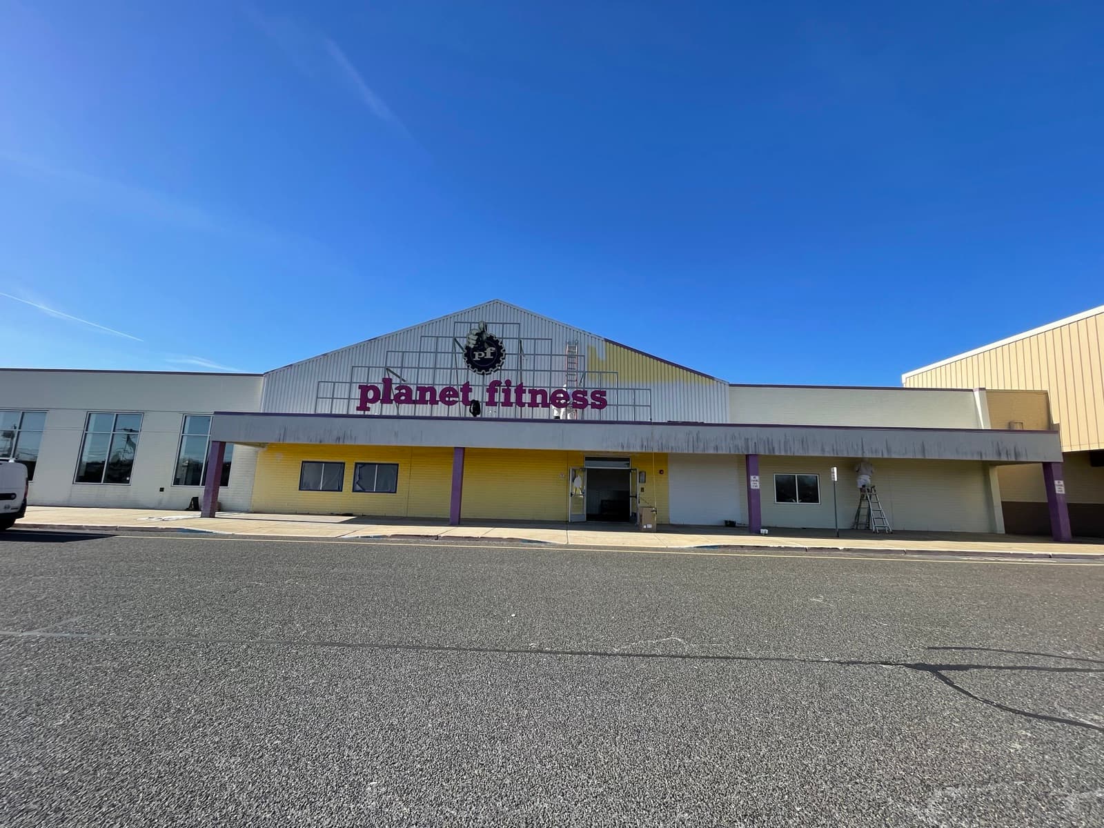 Color House Painters crew on ladders repainting a large commercial gym exterior