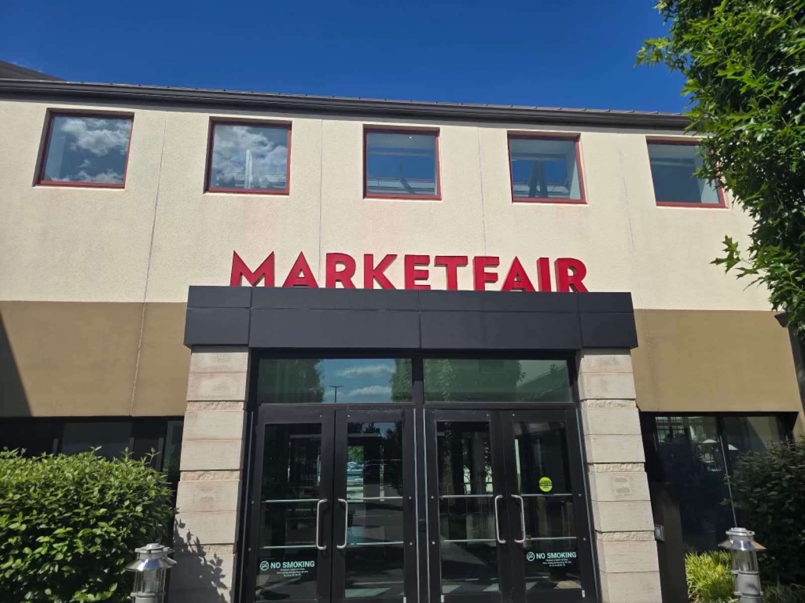 Shopping center entrance with freshly painted stucco and clean red window trim